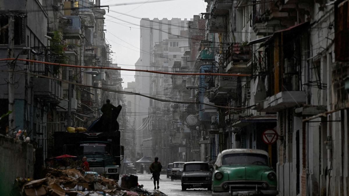 FILE PHOTO: A man walks on a street in the rain as Cuba reconnected its electrical grid across much of the island, according to the Energy and Mines Ministry, following a nationwide blackout that left about 10 million people without electricity, in Havana, Cuba, March 17, 2026. REUTERS/Norlys Perez/File Photo