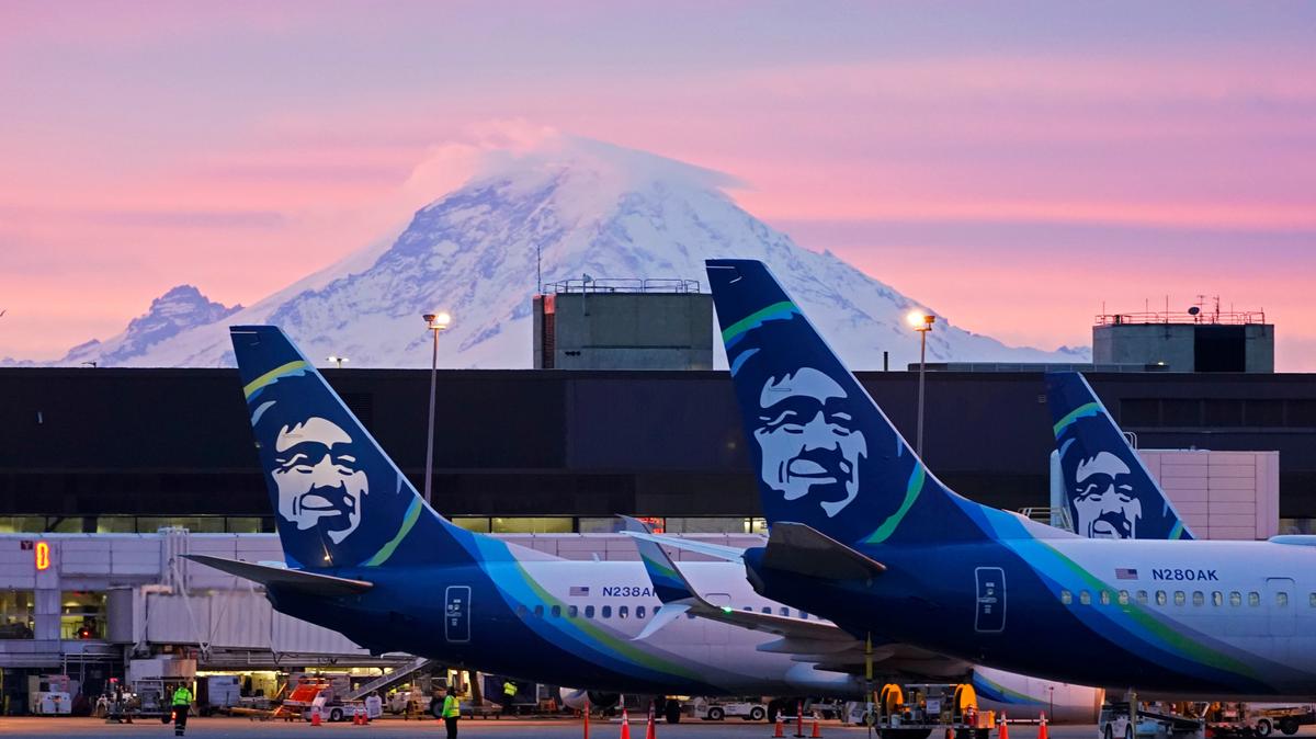 FILE — In this March 1, 2021 file photo Alaska Airlines planes are shown parked at gates with Mount Rainier in the background at sunrise, at Seattle-Tacoma International Airport in Seattle. Alaska Air Group has told its 22,000 employees they will be required to get a COVID-19 vaccination. There are some exceptions to the policy, which has shifted since last month, the The Seattle Times reported. In an email Thursday evening to all Alaska Airlines and Horizon Air employees, the Seattle-based company said employees will now be required to be fully vaccinated or approved for a reasonable accommodation. (AP Photo/Ted S. Warren,File)