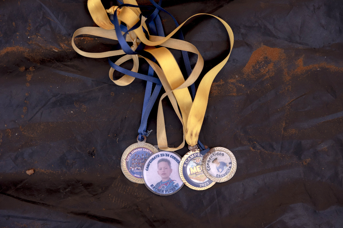 Raymer Flores' baseball medals in La Guaira, Venezuela, on July 1, 2026. He asked his parents to save them, as well as his team hat. (Fabiola Ferrero/The New York Times)