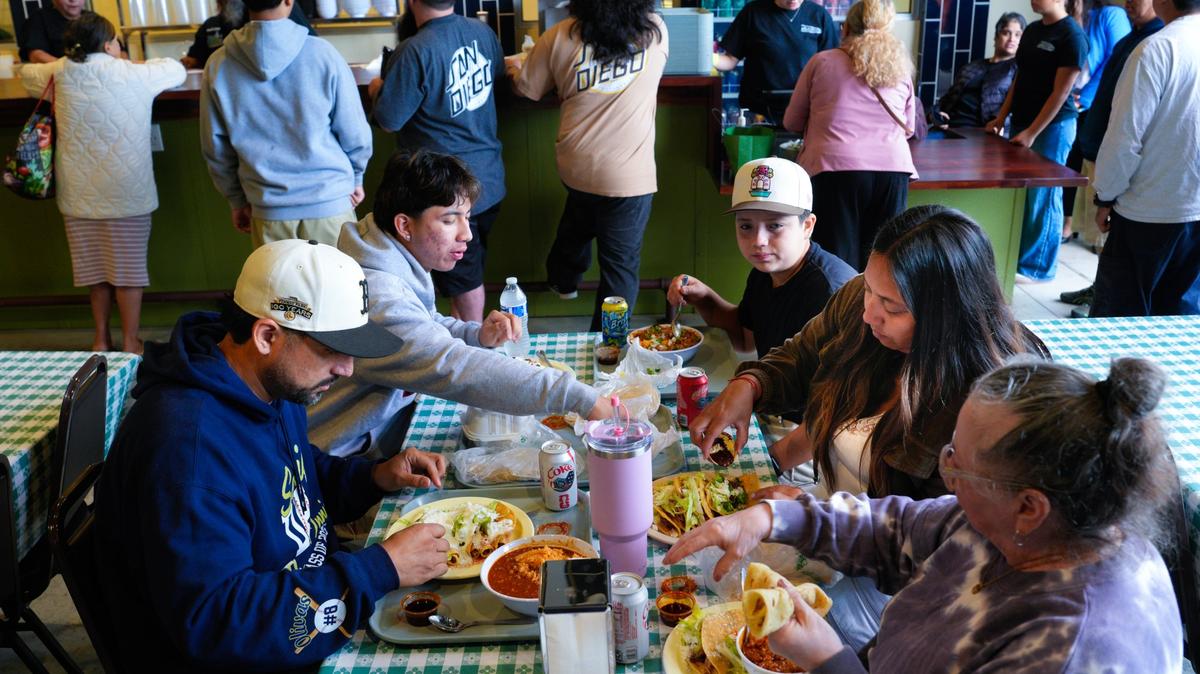 Daniel & Leilani Olivas, along with their two sons, Santiago (l) & Sebastian (r), and his mother-in-law, Margarita Ledesma, enjoy their breakfast at the reopening of Las Cuatros Milpas in Barrio Logan on Tuesday, May 12, 2026, in San Diego, CA. Olivas arrived just after 3am to make sure he was among the first in line to order.  (Nelvin C. Cepeda / The San Diego Union-Tribune)