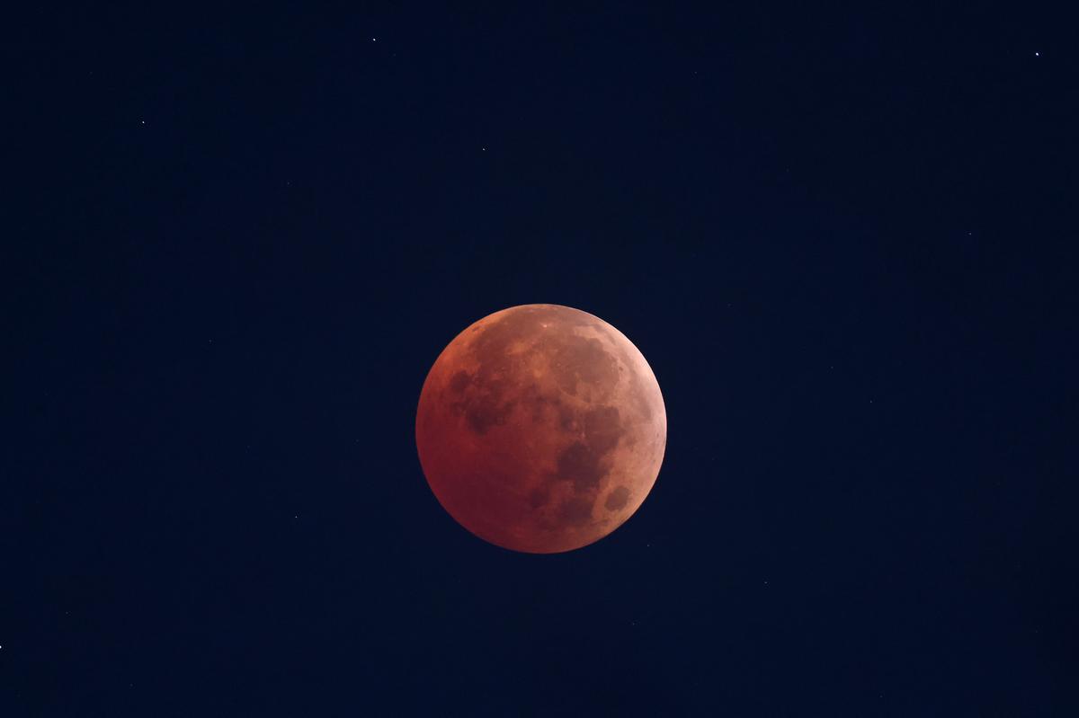 The moon turns a reddish hue as it passes the Earth’s shadow from the sun during a total lunar eclipse early on Nov. 8, 2022. 