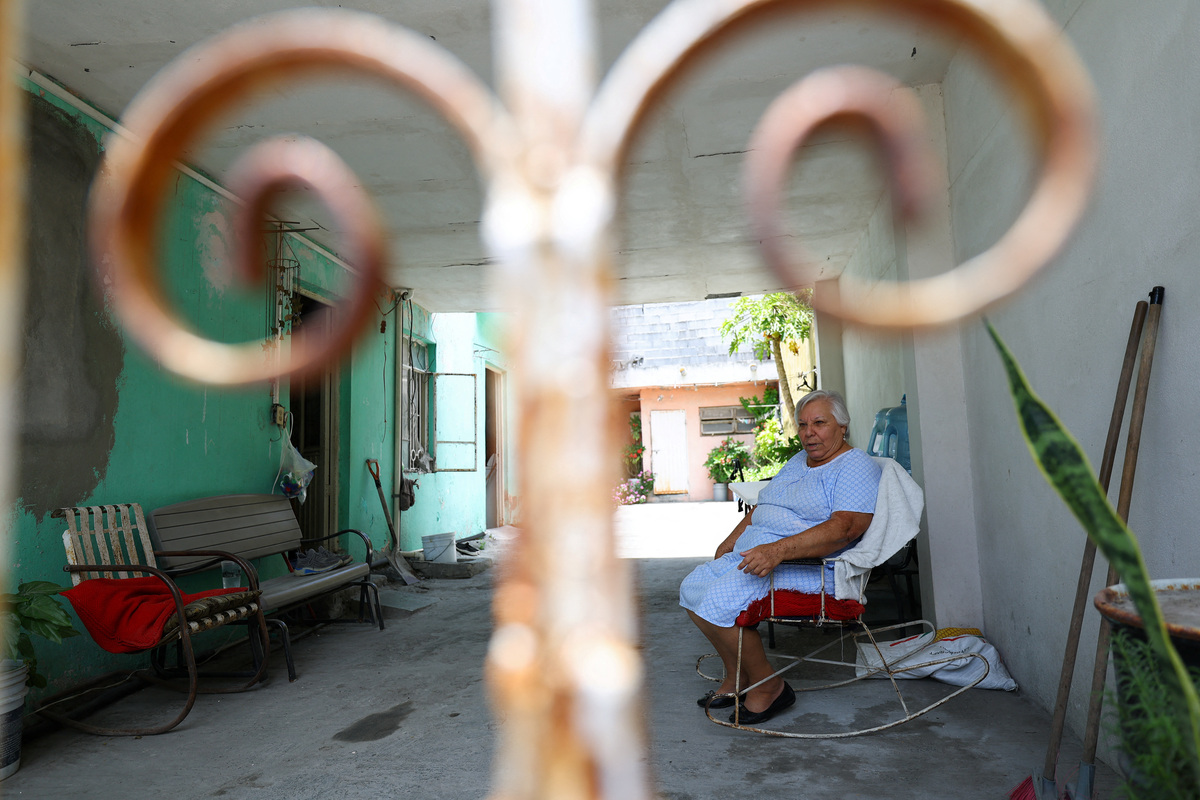 Juanita Barrera, 71, sits at her home as authorities erect walls along roads leading to the stadium and airport to block poorer neighbourhoods from view, as many Mexicans say they feel excluded despite the tournament’s return to the country, citing high ticket prices, paid television access and strict commercial restrictions, in Monterrey, Mexico, June 13, 2026. REUTERS/Daniel Becerril