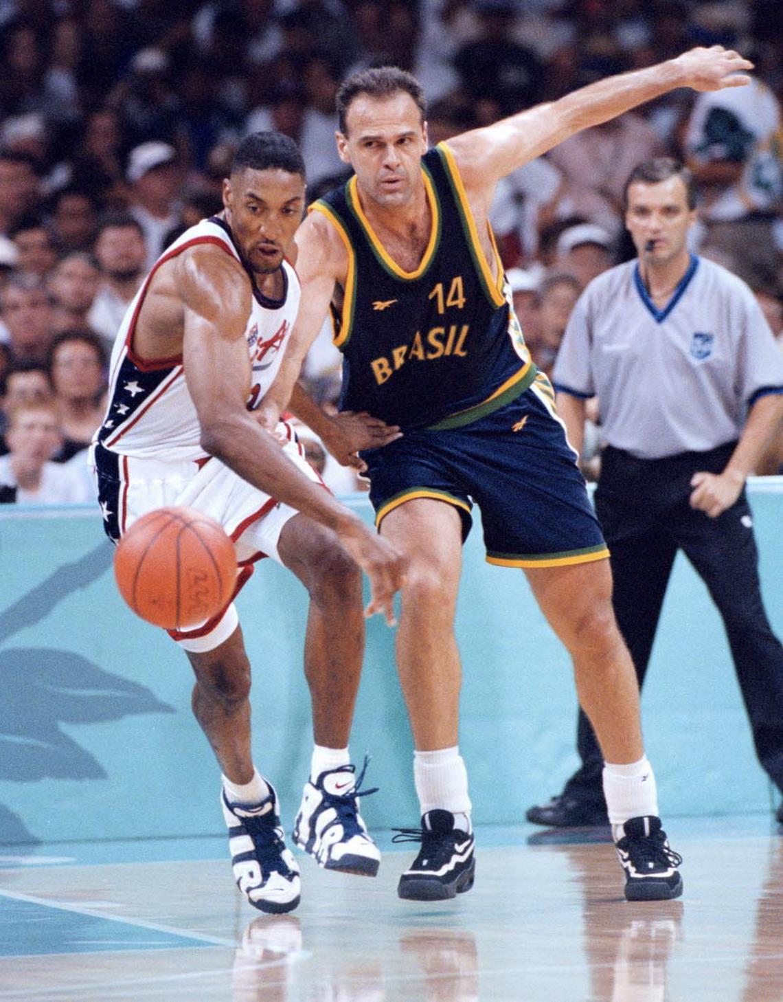 FILE -- Oscar Schmidt of Brazil and Scottie Pippen of the U.S. scramble for a loose ball during a mens' quarterfinal at Summer Olympics in Atlanta on July 30, 1996. Schmidt, who was nicknamed the Holy Hand for shooting prowess and was widely regarded as the best player never to play in the NBA, died in Santana de Parnaiba, Brazil on April 17, 2026. He was 68. (Jose R. Lopez/The New York Times) ..