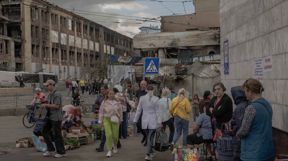 Pedestrians walk past street vendors selling fruits and vegetables next to a heavily damaged building and market following Russian strikes near the Lukianivska metro station in Kyiv on May 27, 2026, amid the Russian invasion of Ukraine. (Roman Pilipey/AFP/Getty Images/TNS)