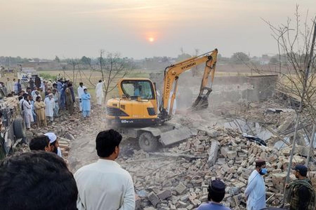 Residents gather as heavy machinery clears the rubble of a damaged police post after a car bombing in Bannu, Khyber Pakhtunkhwa province, Pakistan May 10, 2026. Picture taken with a mobile phone. REUTERS/Ehsan Khattak