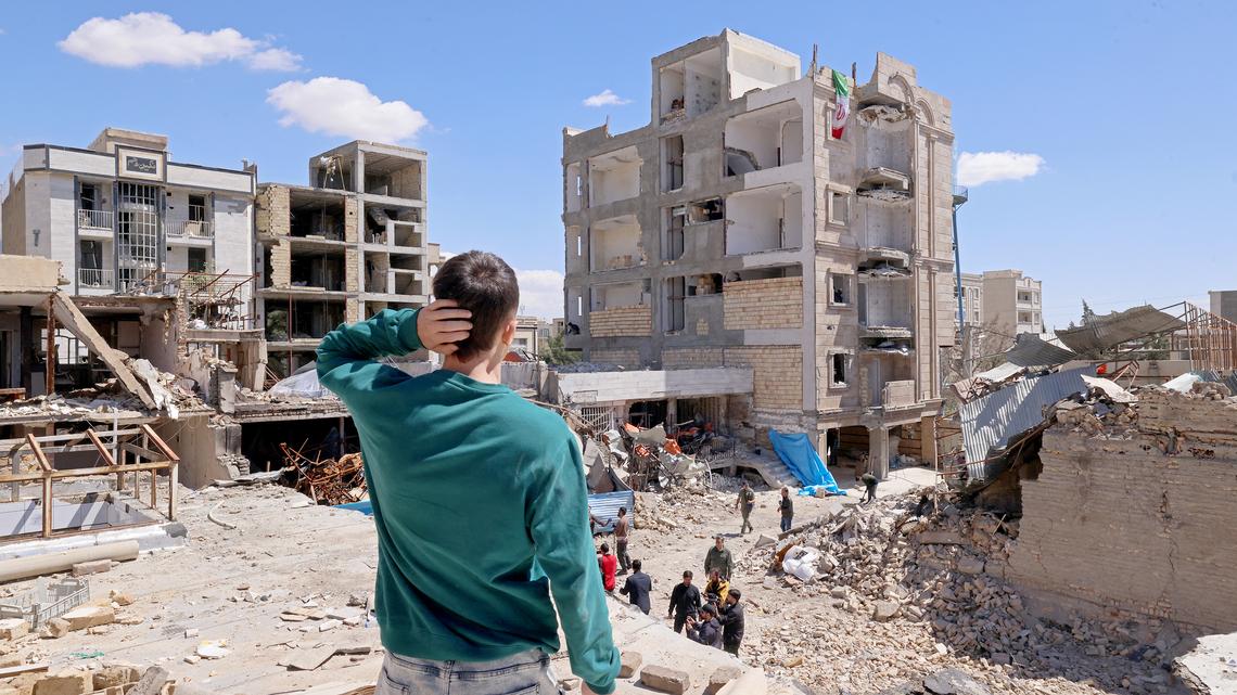 A man looks at the residential buildings damaged by recent strikes at Vahdat town in Karaj, southwest of Tehran, Iran, on April 3. Iran and its allies traded fire with Israel and the United States, as Washington-linked assets across the Middle East were targeted alongside civilian infrastructure with the monthlong war on April 3 showing little sign of easing.