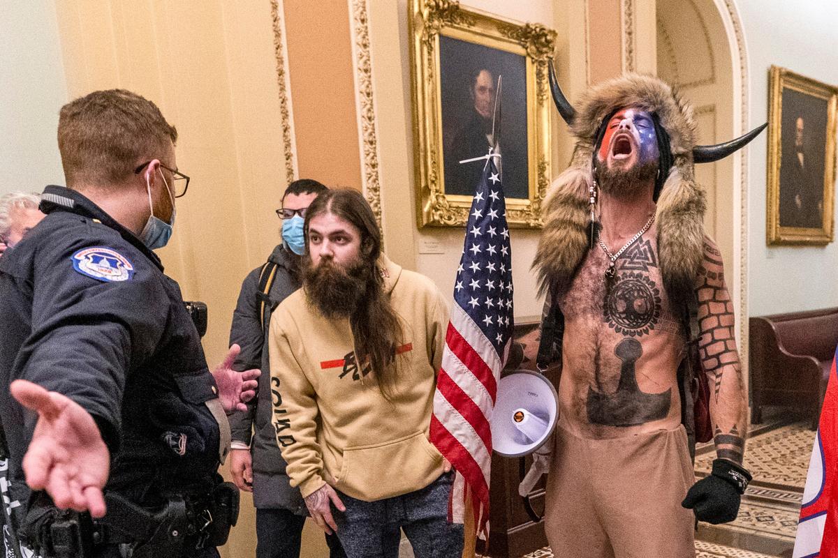 A la derecha, con la cara pintada, un casco con cuernos y sin camisa, se ve a Jacob Chansley durante el asalto al Capitolio en Washington el 6 de enero del 2021. (AP Photo/Manuel Balce Ceneta, File)
