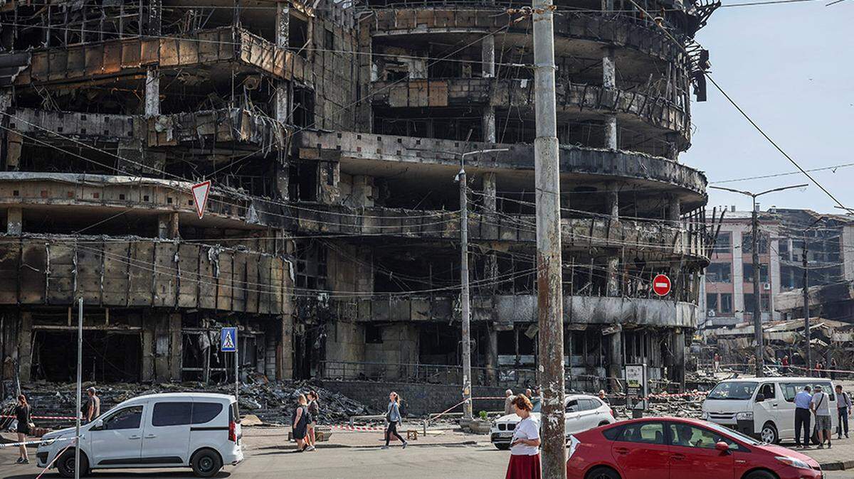 People walk past a destroyed shopping mall, which was hit during the previous day’s Russian missile and drone attack, in Kyiv, Ukraine, on Monday.
