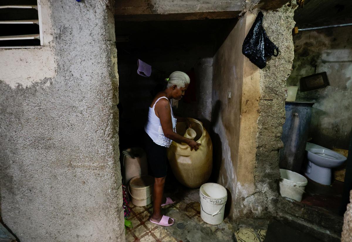 Felicia de la Caridad Alvarez, 64, a former hospital custodian, pours water into a bucket, as Cuba's state-run economy has descended into a full-blown crisis after the administration of U.S. President Donald Trump hardened sanctions and cut off the Caribbean nation's oil supply, in Havana, Cuba May 11, 2026. REUTERS/Norlys Perez