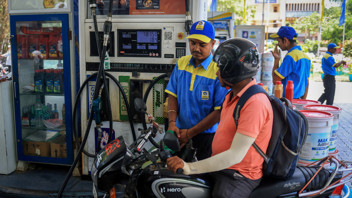 A worker fills a motorcycle's tank with petrol as newly increased fuel prices are displayed at a pump in New Delhi, India, May 19, 2026. REUTERS/Adnan Abidi