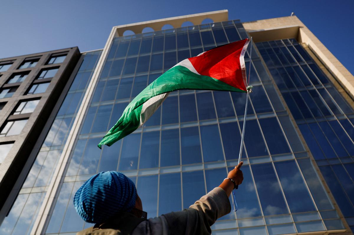 A demonstrator waves a Palestinian flag, during a protest against the U.S. backing of the Israeli military operation in Gaza, outside the Washington office of the American Israel Public Affairs Committee (AIPAC) in Washington, D.C., U.S., September 22, 2025. REUTERS/Daniel Becerril/ File Photo