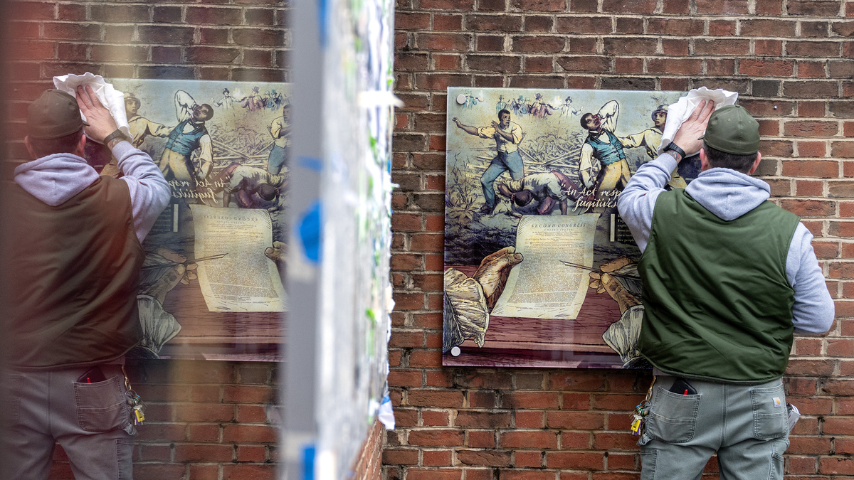 A worker cleans the glass after re-hanging a panel at the President’s House in Independence National Historical Park on Feb, 19, 2026, in Philadelphia. (Tom Gralish/The Philadelphia Inquirer/TNS)