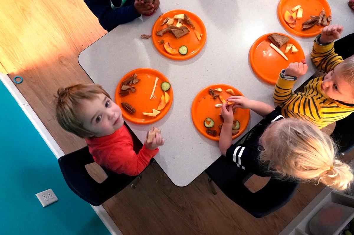 Preschool children eat lunch at a day care facility, Monday, Oct. 25, 2021, in Mountlake Terrace, Wash. Child care centers once operated under the promise that it would always be there when parents have to work. Now, each teacher resignation, coronavirus exposure, and day care center closure reveals an industry on the brink, with wide-reaching implications for an entire economy’s workforce.