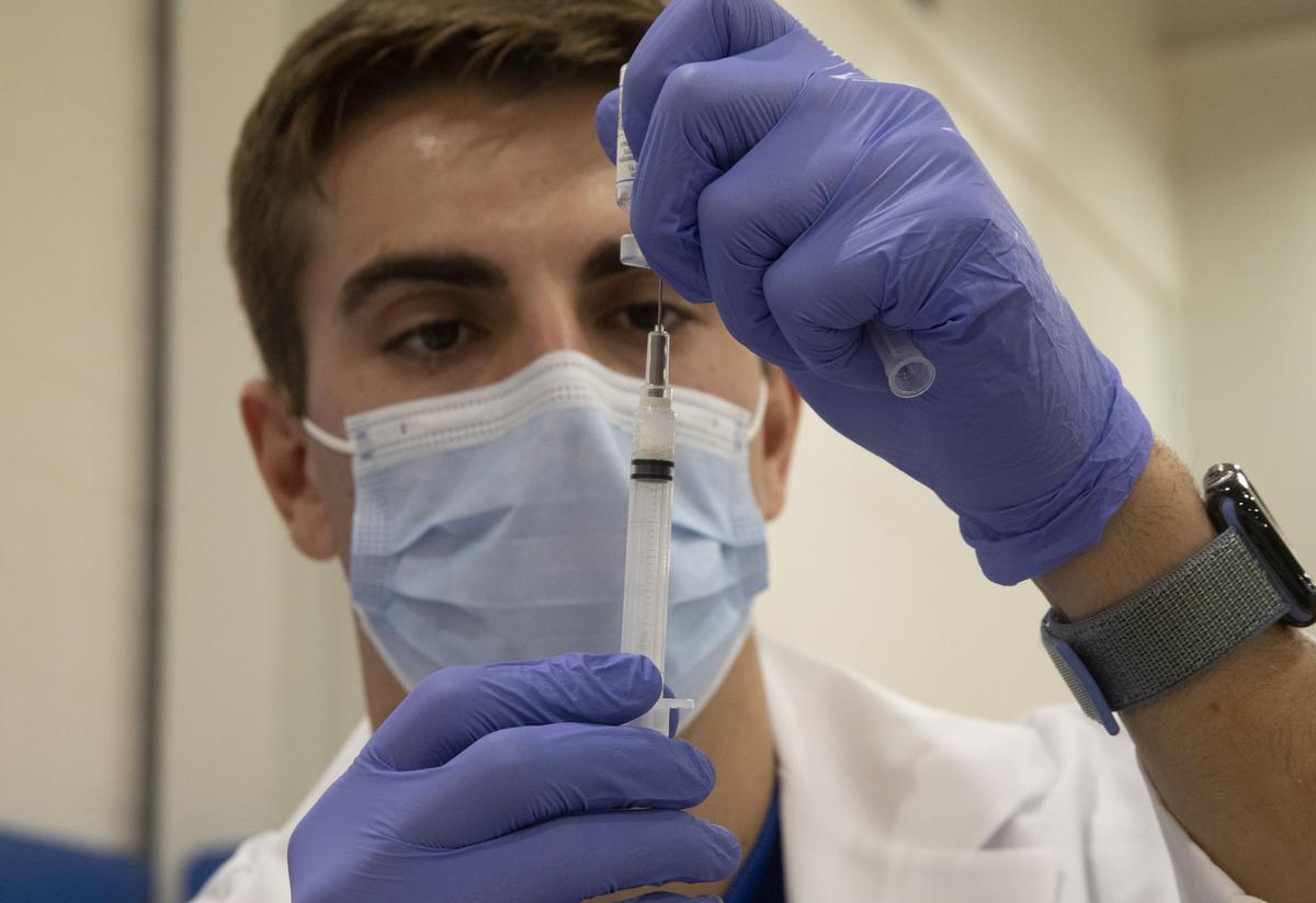 Mark VanDenLangenberg, a volunteer from USF Healths College of Nursing, prepares vaccines in 2022. 