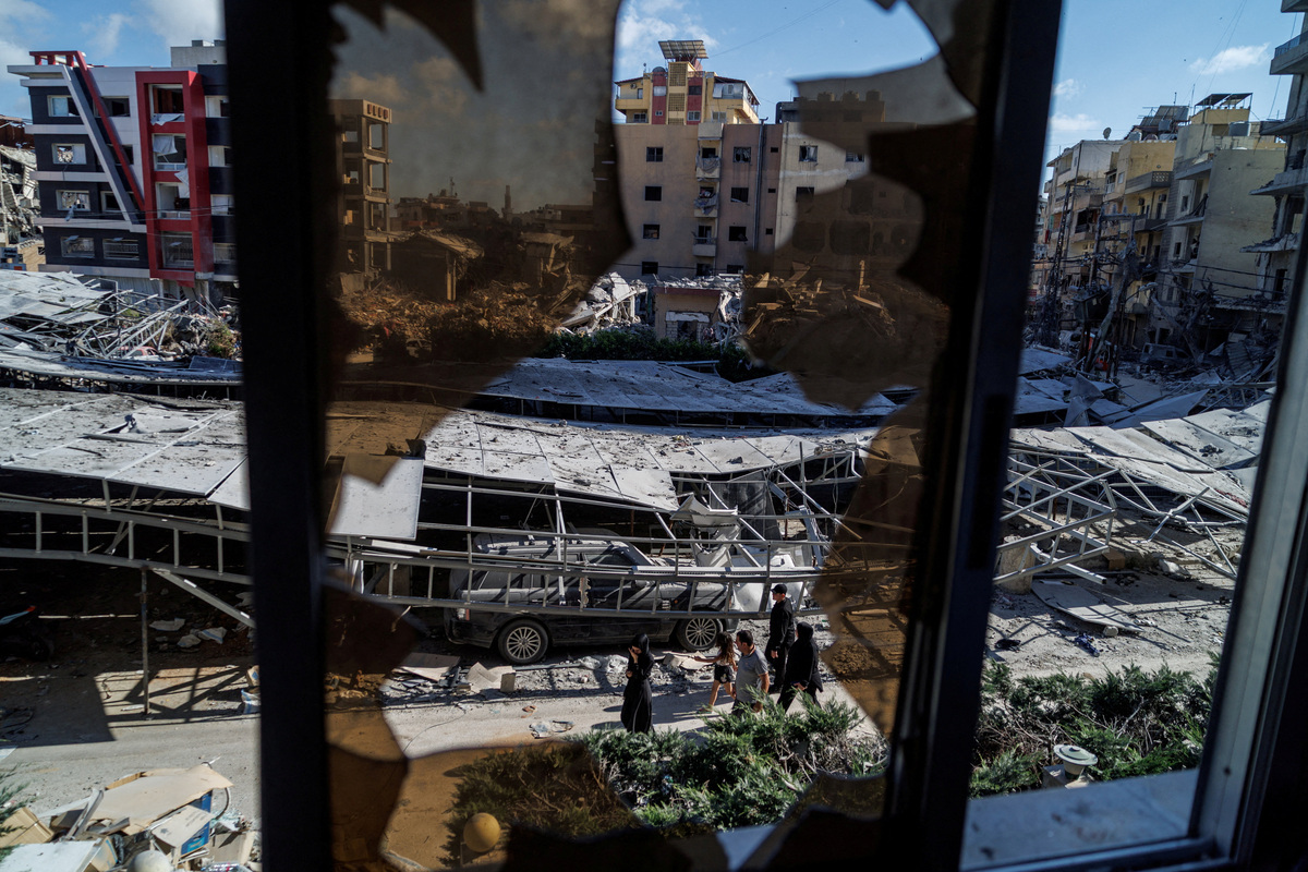 People walk past rubble at the site of an Israeli strike following a deal between the U.S. and Iran in Tyre, southern Lebanon, June 16, 2026. REUTERS/Zohra Bensemra