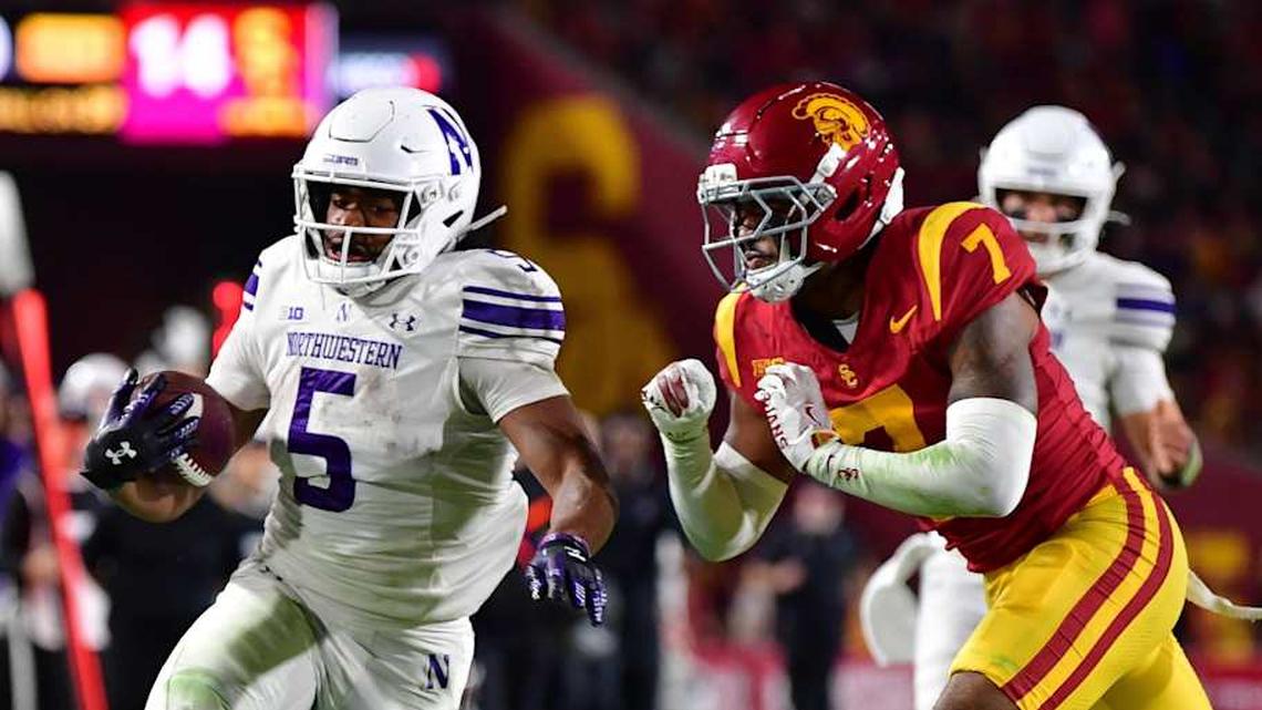  Nov 7, 2025; Los Angeles, California, USA; Northwestern Wildcats running back Caleb Komolafe (5) runs the ball against Southern California Trojans safety Kamari Ramsey (7) during the first half at the Los Angeles Memorial Coliseum. Mandatory Credit: Gary A. Vasquez-Imagn Images | Gary A. Vasquez-Imagn Images 