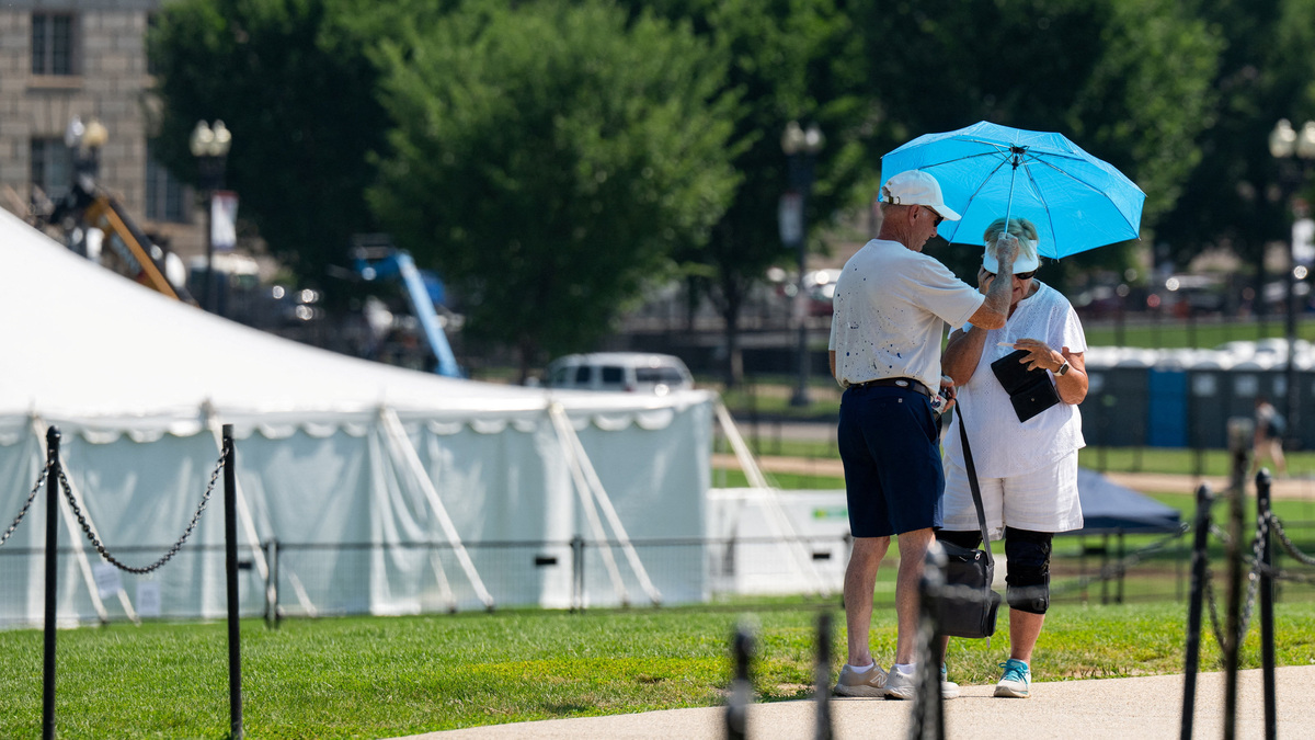 Tourists use an umbrella to block the sun as excessive heat hits Washington, D.C., U.S., July 1, 2026. REUTERS/Annabelle Gordon