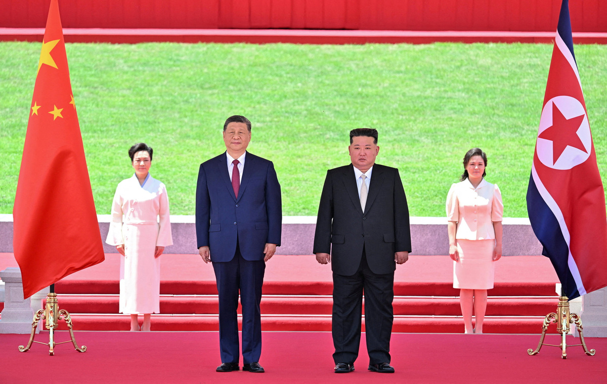 Chinese President Xi Jinping and North Korean leader Kim Jong Un watch a march-past as Kim holds a welcome ceremony for Xi at Kim Il Sung Square in Pyongyang, North Korea June 8, 2026. Yin Bogu/Xinhua via REUTERS