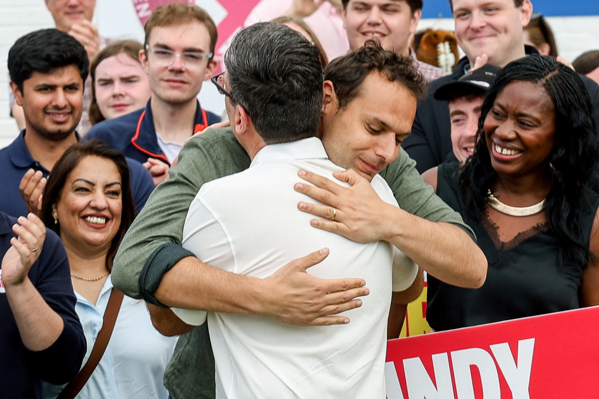 Outgoing Greater Manchester Mayor and newly elected Makerfield MP Andy Burnham hugs former Labour MP Josh Simons at the Bartons Group Stadium, as Burnham addresses members and supporters of the Labour Party after he won the Makerfield by-election, in Ashton-in-Makerfield, Britain, June 19, 2026. REUTERS/Temilade Adelaja