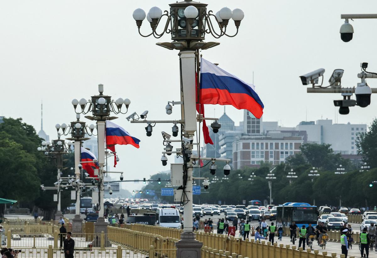 Russian and Chinese flags flutter on lighting poles in Tiananmen Square as traffic passes by, ahead of Russian President Vladimir Putin's visit to China, in Beijing, China, May 19, 2026. REUTERS/Maxim Shemetov