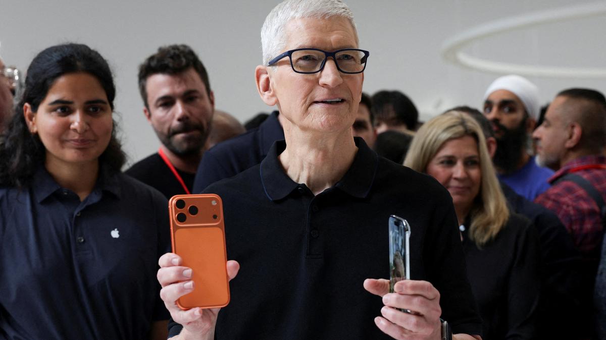 Apple CEO Tim Cook holds an iPhone 17 pro and an iPhone Air, as Apple holds an event at the Steve Jobs Theater on its campus in Cupertino, California, U.S. September 9, 2025. REUTERS/Manuel Orbegozo