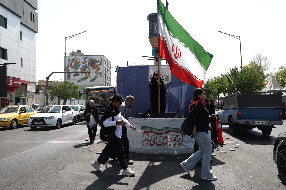 A woman holds an Iranian flag on a street in Tehran, Iran, June 10, 2026. Majid Asgaripour/WANA (West Asia News Agency) via REUTERS