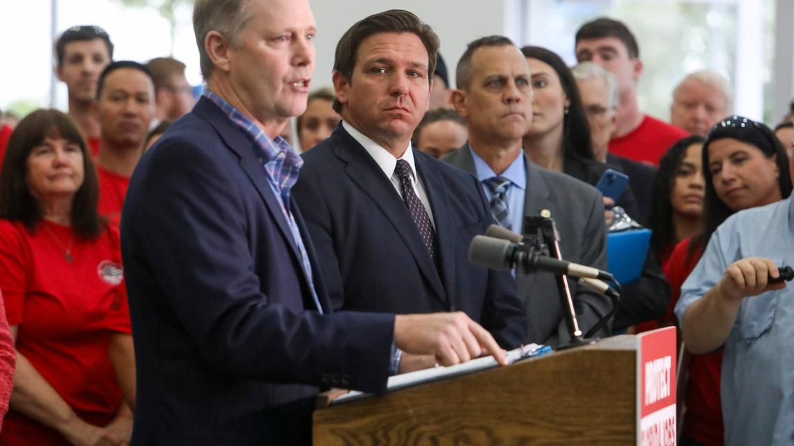 Then-Senate President Wilton Simpson speaks while Gov. Ron DeSantis listens nearby before signing bills to limit COVID-19 vaccine mandates on private, state government employees and school districts, in Brandon on Thursday, Nov. 18, 2021.