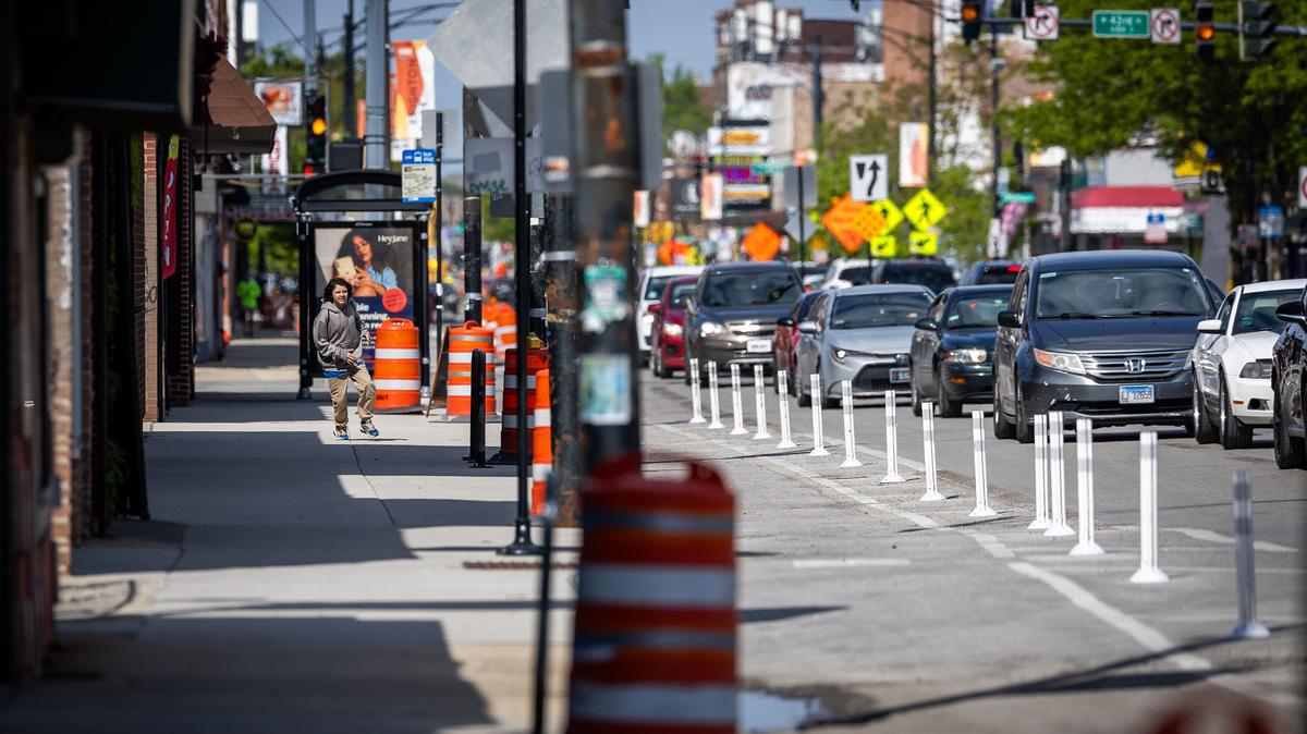 A person runs on the sidewalk as traffic builds along South Archer Avenue in Chicago's Brighton Park neighborhood on May 6, 2026. (Josh Boland/Chicago Tribune/TNS)