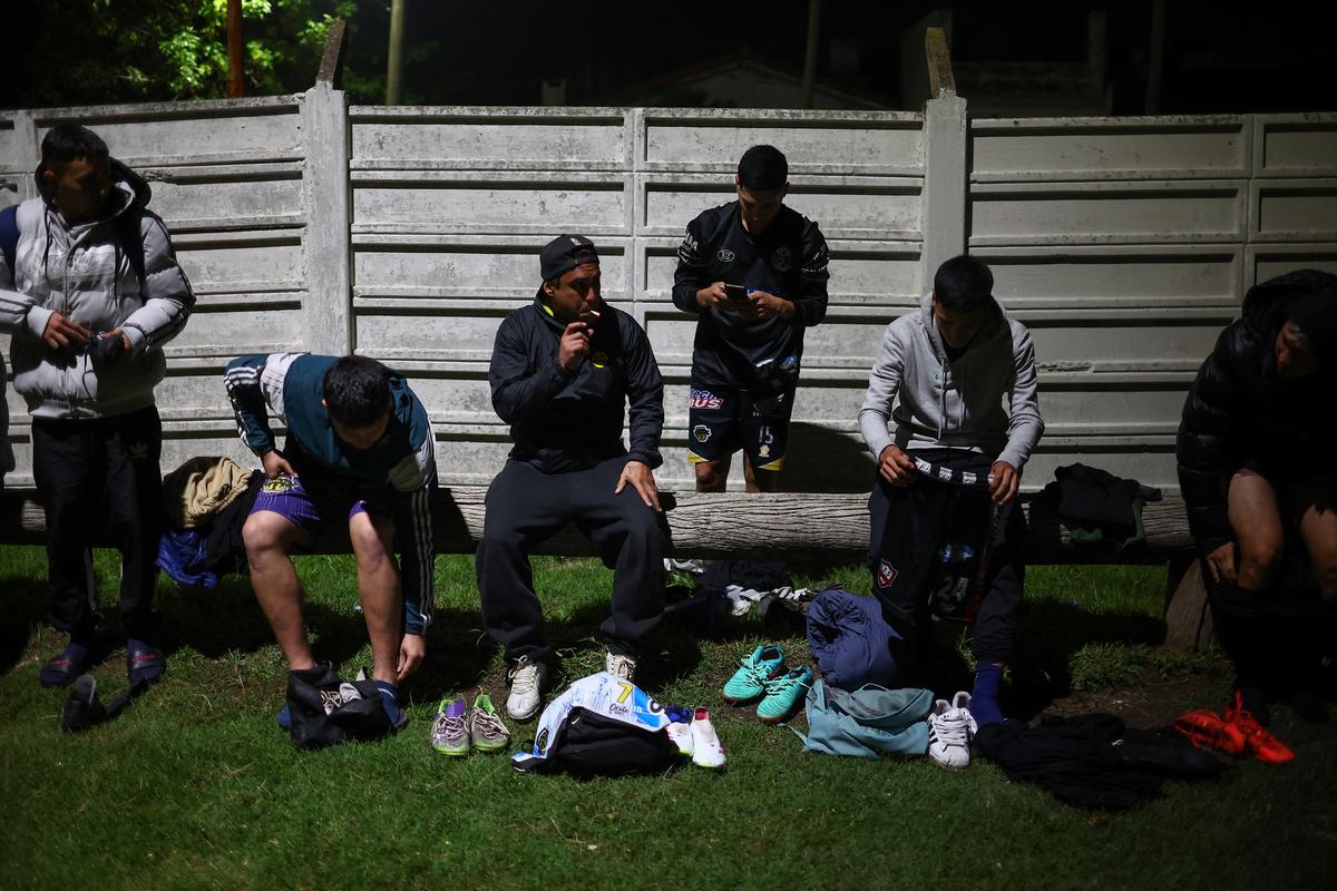 Emiliano Migueles' teammates get ready prior to an informal soccer match played for a cash prize of 300,000 Argentine pesos (215 USD), which is shared among players, in Ciudad Evita, on the outskirts of Buenos Aires, Argentina, April 9, 2026. For three-time World Cup champions Argentina, football is a feverish passion that permeates every home and every makeshift dirt field, known as a "potrero.” Many matches at these potreros offer players the chance to win some cash. The amounts are tiny compared to the wages of their compatriots who play in the glittering European leagues and will soon seek to defend their 2022 World Cup win. But potrero players can sometimes earn enough to help pay the bills. REUTERS/Agustin Marcarian