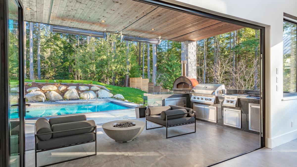 A very large modern contemporary private residence residential home spacious interiors living room, kitchen, office, recreation room, foyer, hallway, floating staircase window wall open to a patio with BBQ and swimming pool. New construction family home