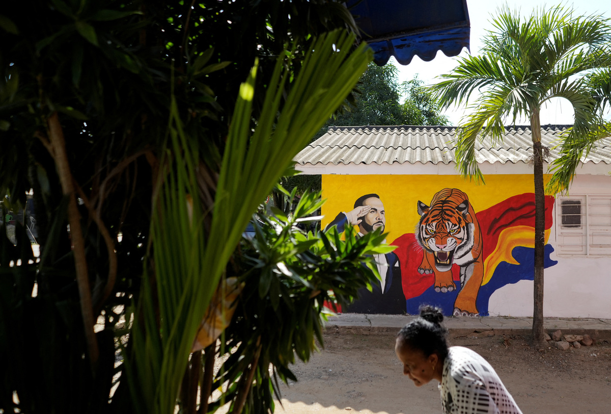 A woman walks in front of electoral advertisements of right-wing presidential candidate Abelardo De La Espriella, ahead of the 21 June runoff between De La Espriella and leftist candidate Ivan Cepeda, in Juan de Acosta, Colombia, June 11, 2026. REUTERS/Charlie Cordero