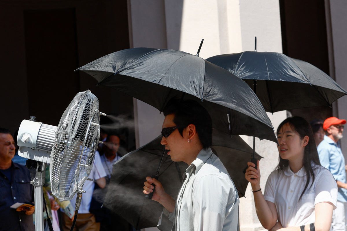 A man stands in front of a cooler spraying water ahead of Thom Browne’s Spring/Summer 2027 men’s collection show as part of Milan Fashion Week, in Milan, Italy, June 22, 2026. REUTERS/Alessandro Garofalo