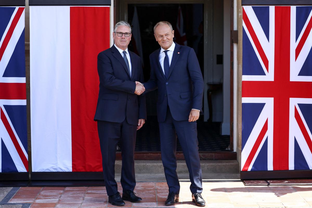 Britain's Prime Minister Keir Starmer welcomes Poland's Prime Minister Donald Tusk on his arrival at RAF Northolt, as the countries formalise a UK-Poland security agreement, at RAF Northolt, near Uxbridge, Britain, May 27, 2026. REUTERS/Jack Taylor/Pool