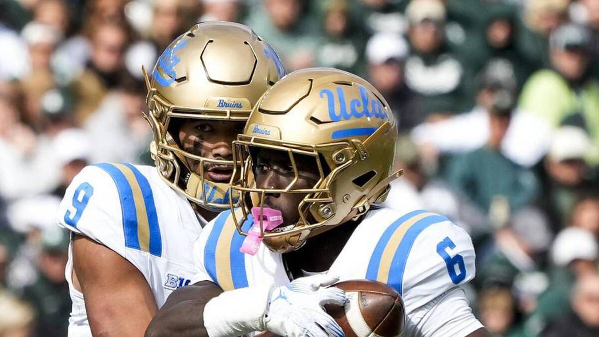  Oct 11, 2025; East Lansing, Michigan, USA; UCLA Bruins quarterback Nico Iamaleava (9) hands the ball off to running back Anthony Woods (6) in the second quarter at Spartan Stadium. Mandatory Credit: Brendan Mullin-Imagn Images | Brendan Mullin-Imagn Images 