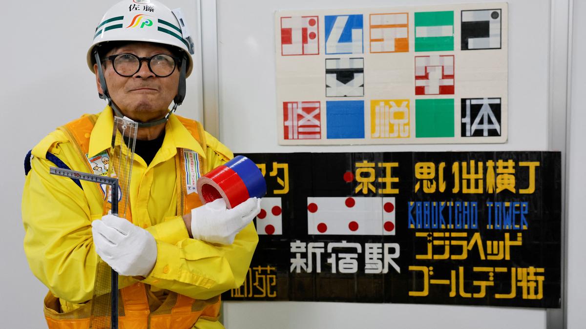Shuetsu Sato, a security guard whose handmade duct-tape signs have gained widespread recognition, poses with duct-tape signs which he made at a security company office where he works, in Tokyo, Japan, May 1, 2026. REUTERS/Kim Kyung-Hoon