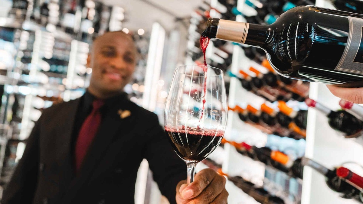 Wine is poured into a glass in a Celebrity Cruises on board wine cellar.