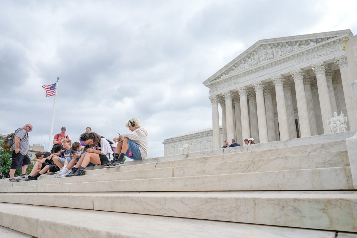  Visitors sit on the steps of the U.S. Supreme Court in Washington on June 8, 2026. AP Photo/Mariam Zuhaib 
