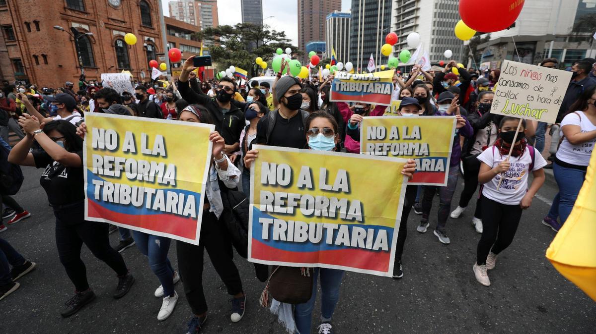 Manifestantes sostienen carteles que dicen en español “No a la reforma tributaria” durante un paro nacional contra una reforma tributaria propuesta por el gobierno, en Bogotá, Colombia, el miércoles 28 de abril de 2021. (AP Foto/Fernando Vergara)