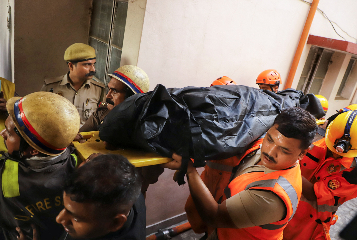 Firefighters recover a victim after a deadly fire at a coaching centre in Lucknow, India, June 22, 2026. REUTERS/Naeem Ansari