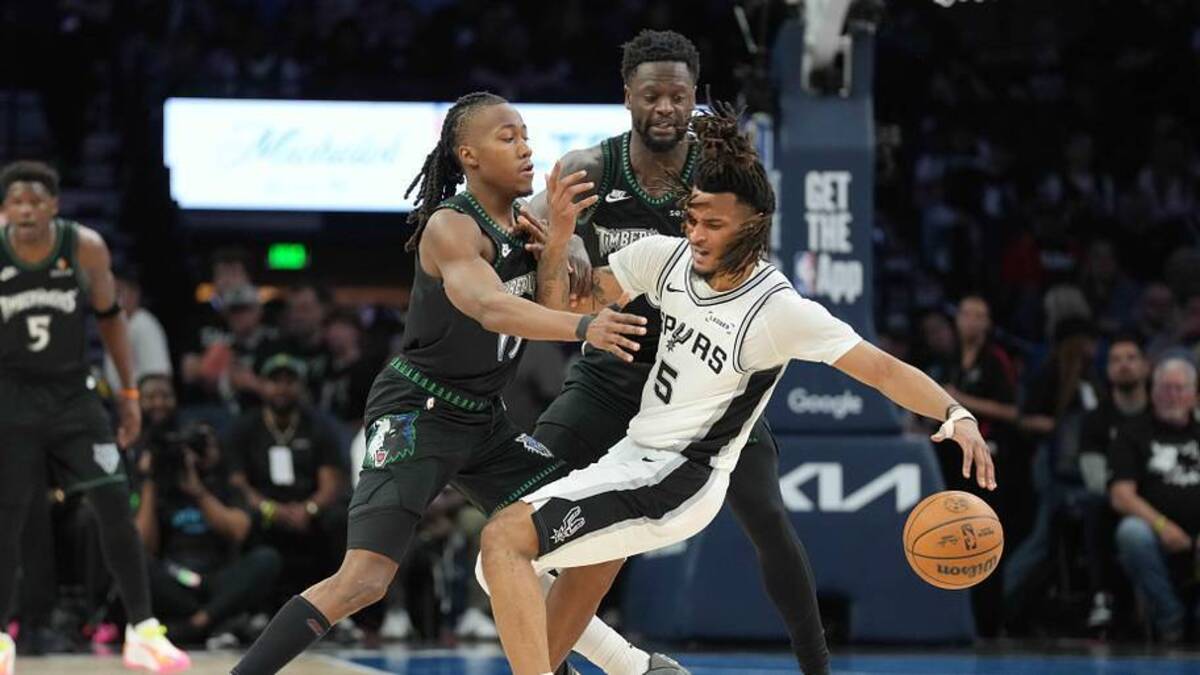  May 15, 2026; Minneapolis, Minnesota, USA; San Antonio Spurs guard Stephon Castle (5) dribbles the ball as Minnesota Timberwolves guard Ayo Dosunmu (13) and forward Julius Randle (30) plays defense in the second half during game six of the second round of the 2026 NBA Playoffs at Target Center. Mandatory Credit: Jesse Johnson-Imagn Images | Jesse Johnson-Imagn Images 