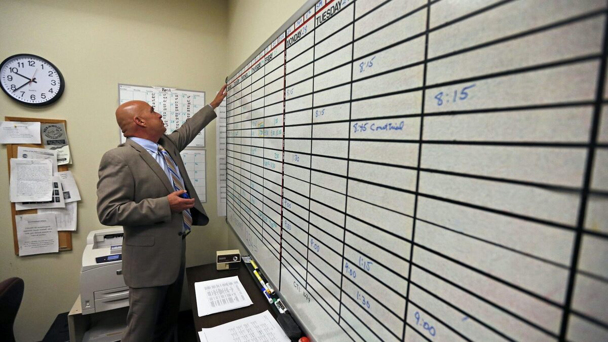 A court interpreter checks the day's schedule of assignments. 