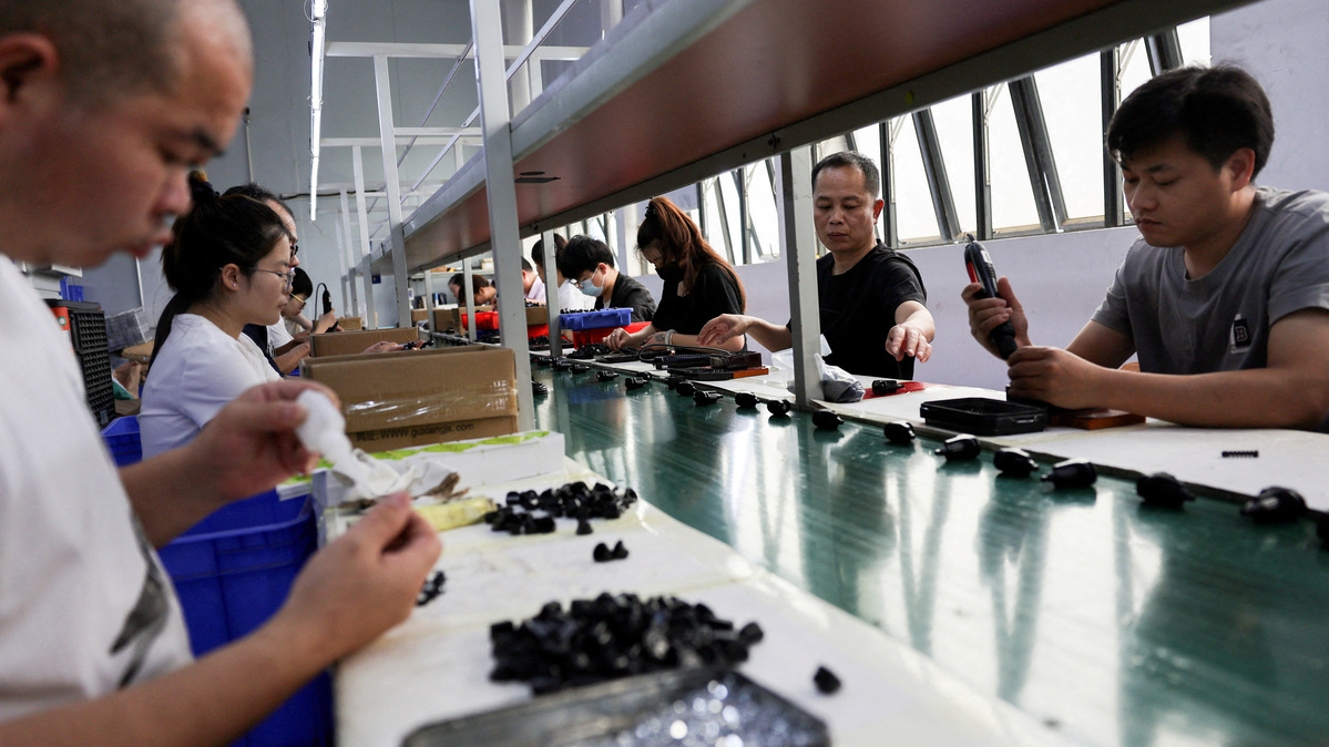 FILE PHOTO: Employees work at an assembly line producing car smartphone holders at a plastic accessories factory, as rising oil prices drive up production costs for plastic manufacturers, in Dongguan, Guangdong province, China, April 2, 2026.  REUTERS/Go Nakamura/File Photo