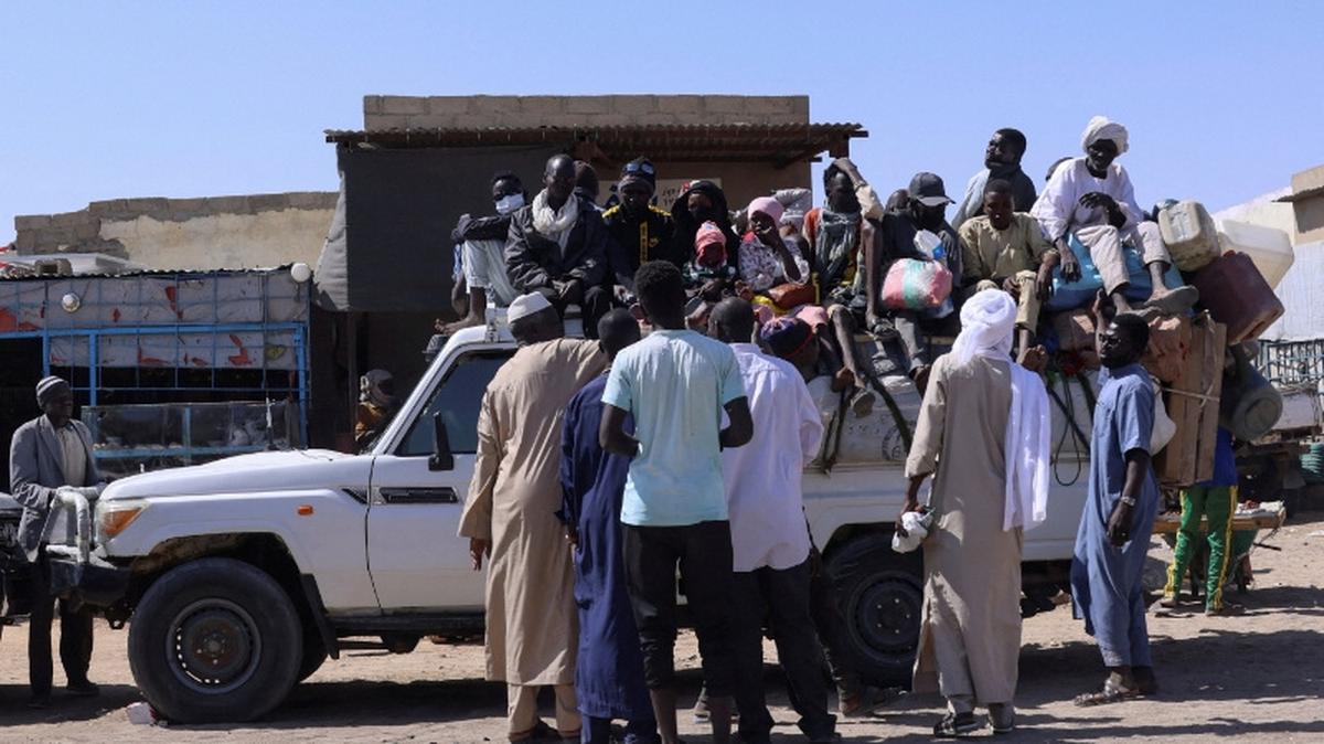 FILE PHOTO: People sit on a pickup truck as they prepare to travel about 250 km south to Adre, on the Chad-Sudan border, at a transport station in Tine, eastern Chad, November 25, 2025. REUTERS/Amr Abdallah Dalsh/File Photo