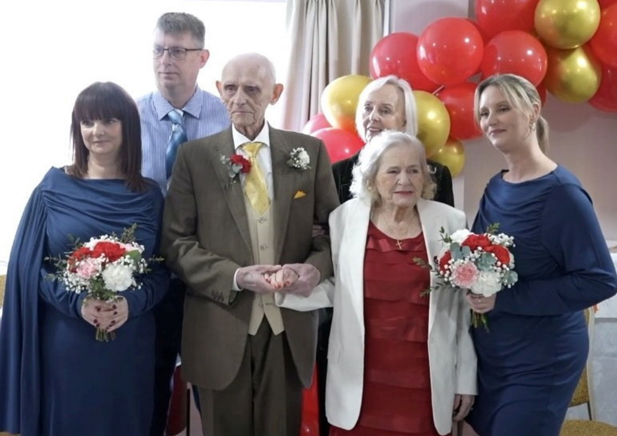  The groom wore a brown suit with a gold tie while the bride wore a red top, and a white blazer. (Charlton Grange Care Home via SWNS) 