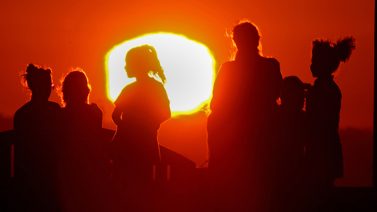 A blazing sun silhouettes visitors to Signal Hill after another hot day across Southern California, on Sept. 1, 2022, with a brutal heatwave expected to last through the Labor Day weekend. (Luis Sinco/Los Angeles Times/TNS)