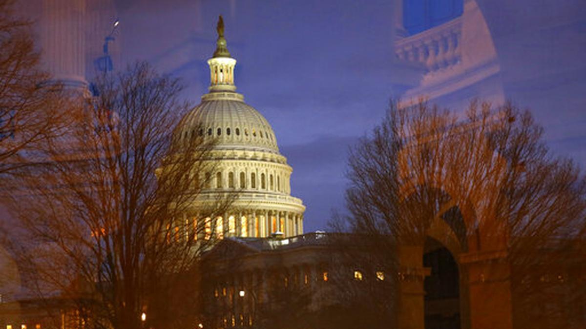 Light illuminates the U.S. Capitol dome as it is seen though window reflections in Washington.