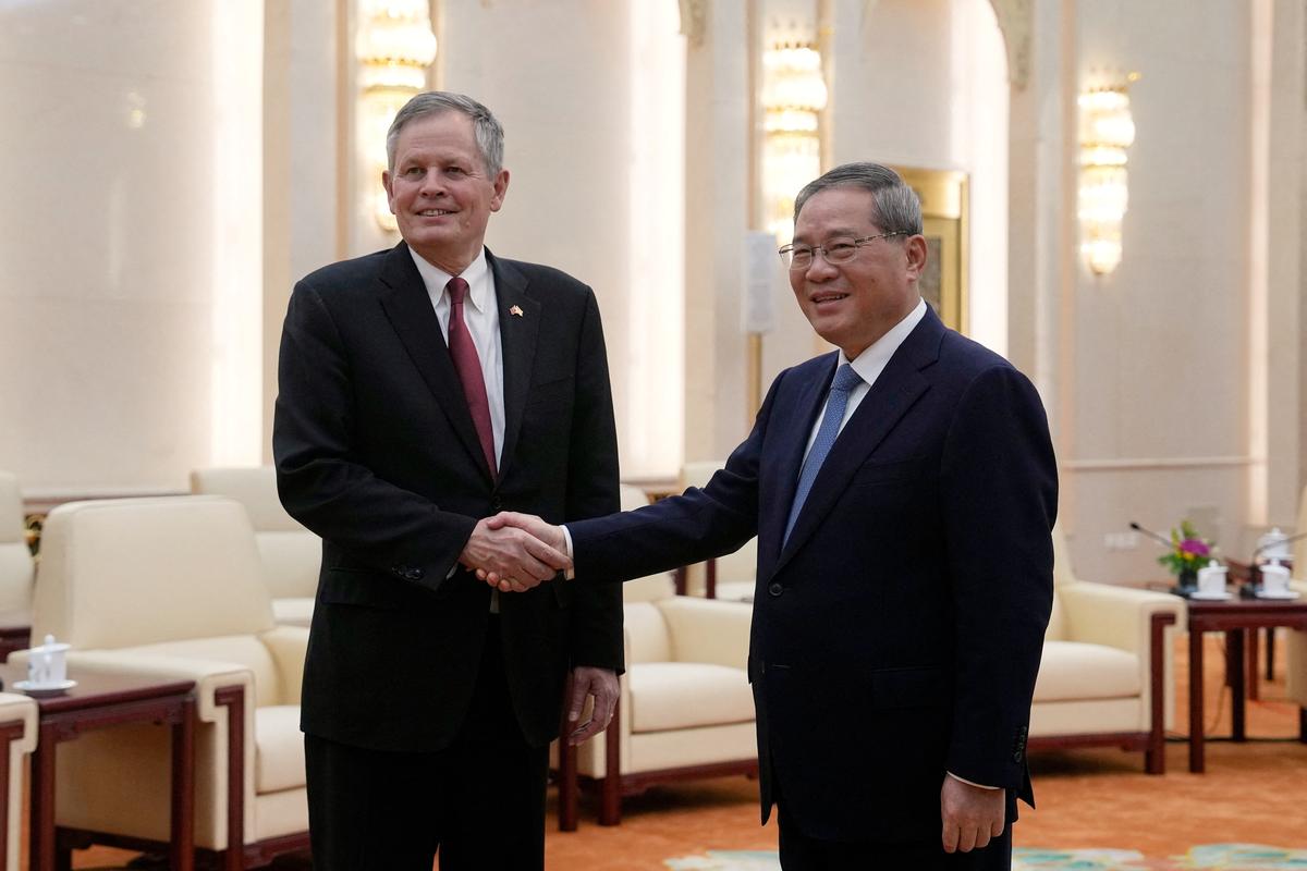 U.S. Senator Steve Daines, left, and Chinese Premier Li Qiang pose for a photoshoot session prior to a meeting at the Great Hall of the People, in Beijing, Thursday, May 7, 2026.     Andy Wong/Pool via REUTERS