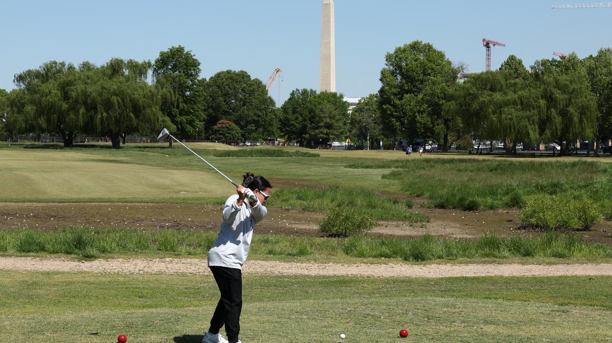 With the Washington Monument in the background, a golfer tees off at East Potomac Golf Course, whose future is in the courts as the Trump administration plans to take over operations and close it down to begin maintenance work, in Washington, D.C., U.S., May 4, 2026. REUTERS/Kevin Lamarque