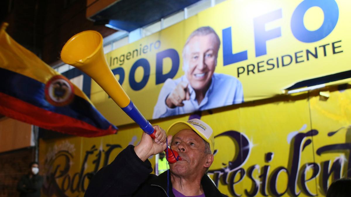 Un partidario de Rodolfo Hernández, candidato presidencial de la Liga de Gobernadores Anticorrupción, toca una bocina frente a los carteles de campaña del candidato en la noche de las elecciones en Bogotá, Colombia, el domingo 29 de mayo de 2022. Hernández avanzó a la segunda vuelta en Bogotá, Colombia, el 19 de junio después de que ninguno de los seis candidatos en la primera ronda del domingo obtuviera el 50% de los votos. (Foto AP/Leonardo Muñoz)