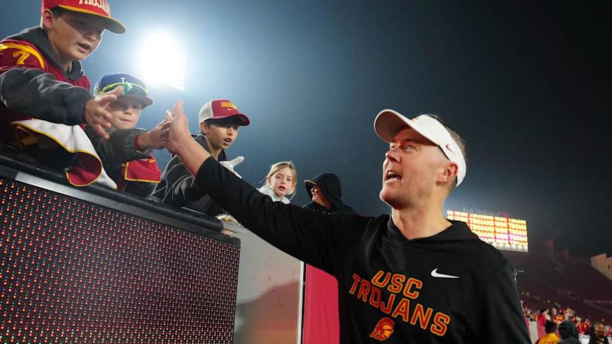  Nov 29, 2025; Los Angeles, California, USA; Southern California Trojans head coach Lincoln Riley celebrates with fans after the game against the UCLA Bruins at United Airlines Field at Los Angeles Memorial Coliseum. Mandatory Credit: Kirby Lee-Imagn Images | Kirby Lee-Imagn Images 